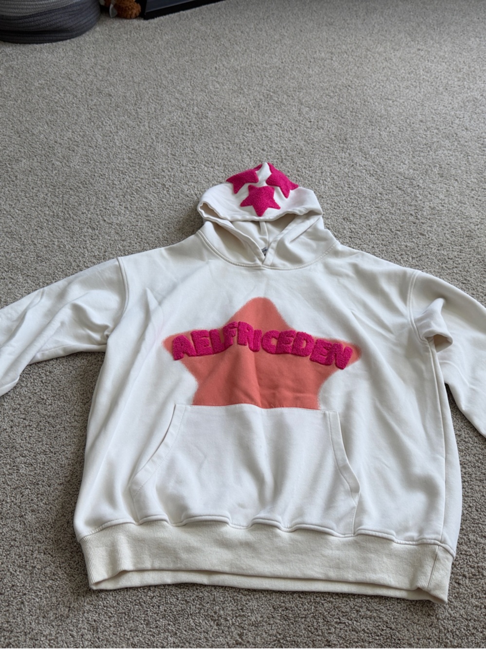 Aelfriceden Cream Hoodie with Hot Pink Star Accents and Coral Chest Panel